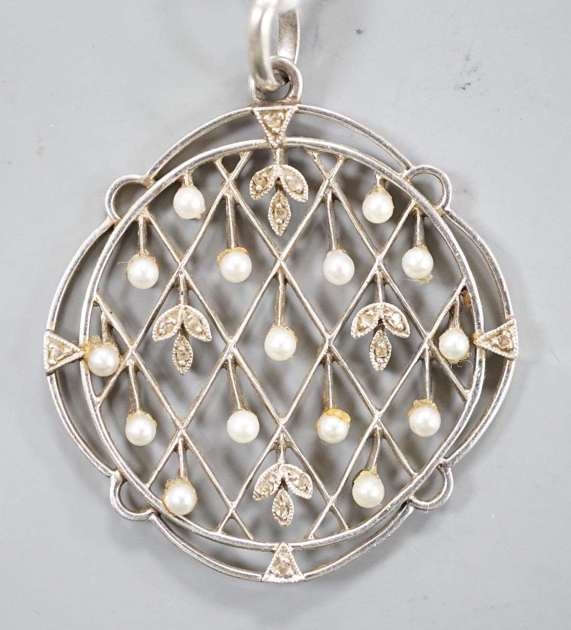 An early 20th century white metal, rose cut diamond chip and seed pearl set openwork pendant, diameter 31mm, gross weight 5.5 grams.
